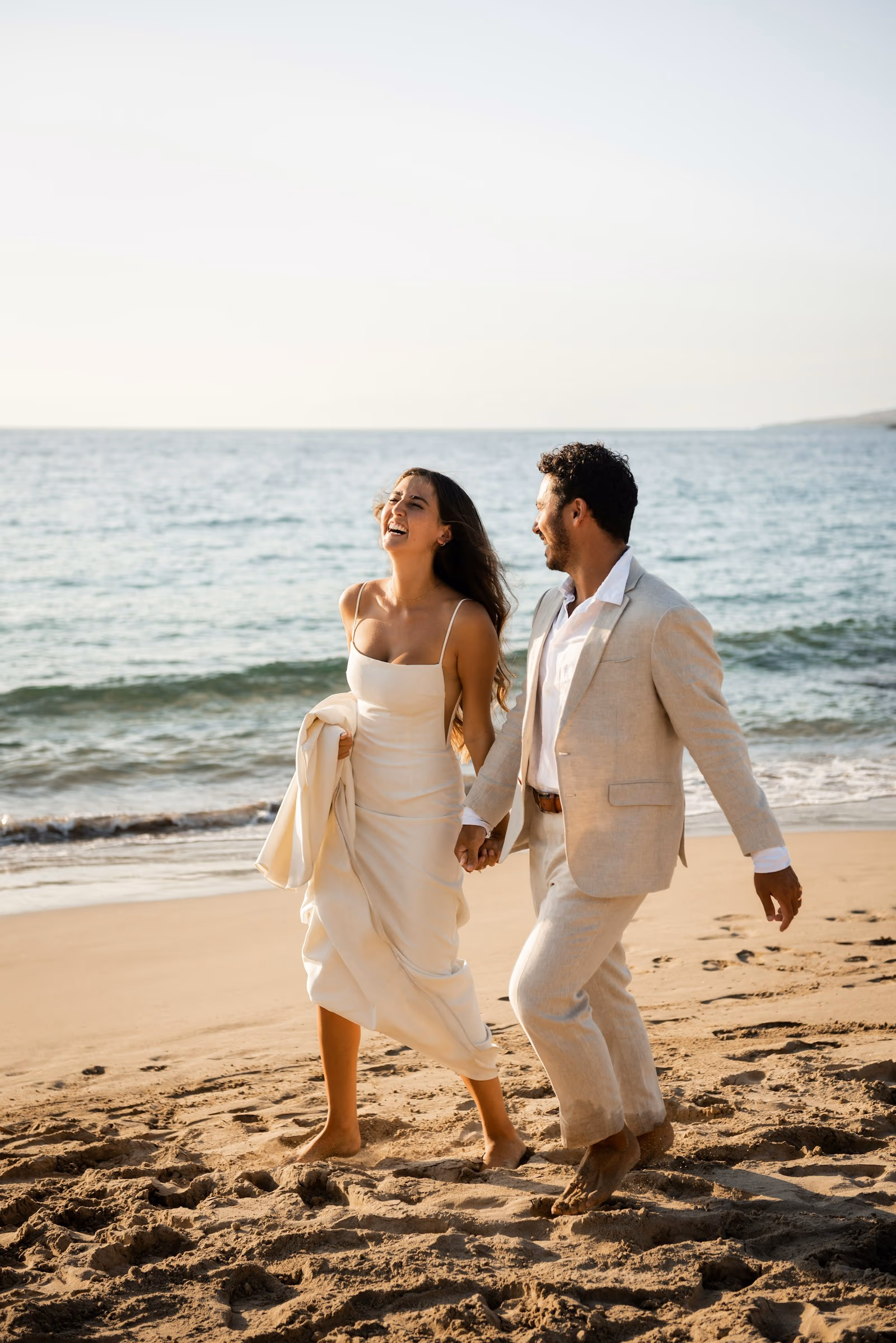 Jeunes mariés courant sur la plage